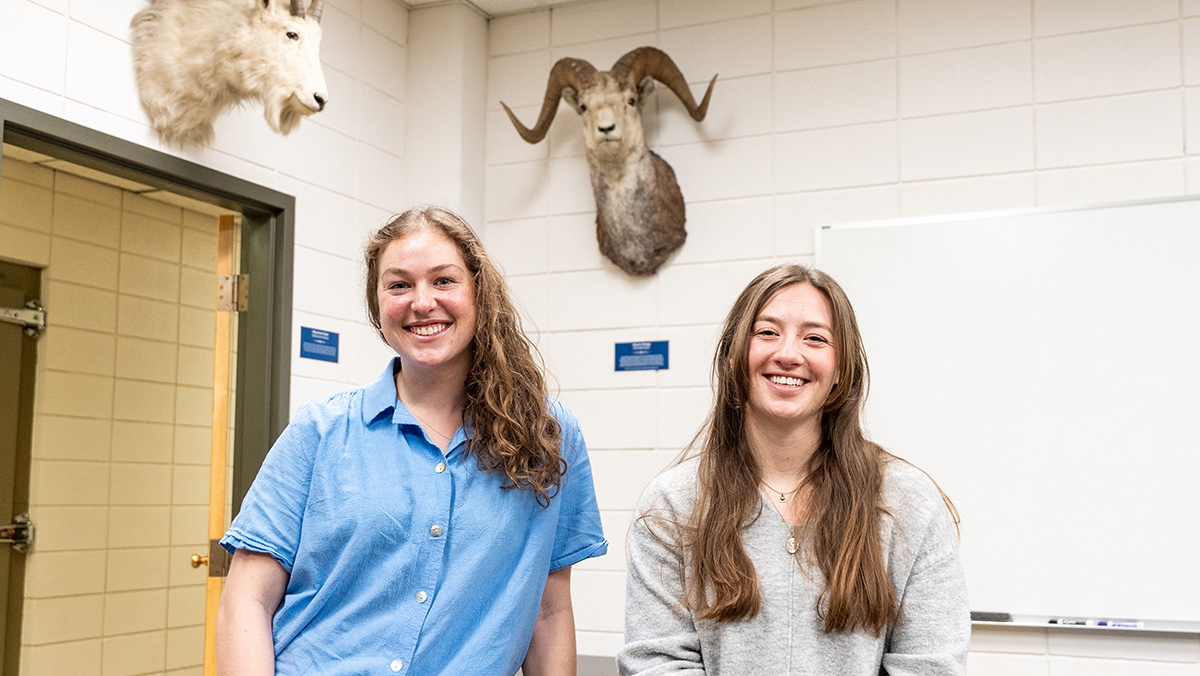 Two women stand in a lab smiling 